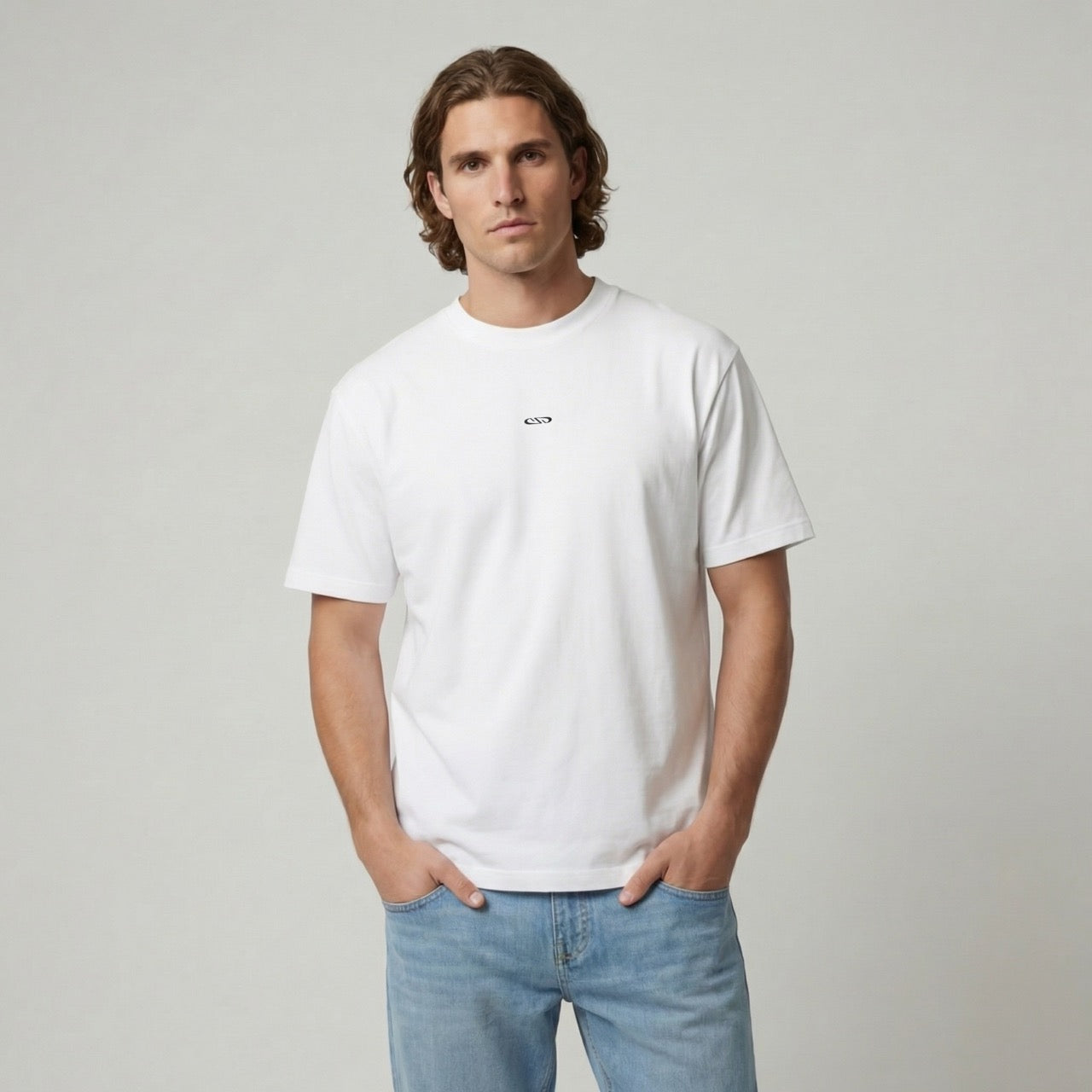 Man draagt wit Humae T-shirt van Nouve Studios met subtiele borstprint op de voorkant