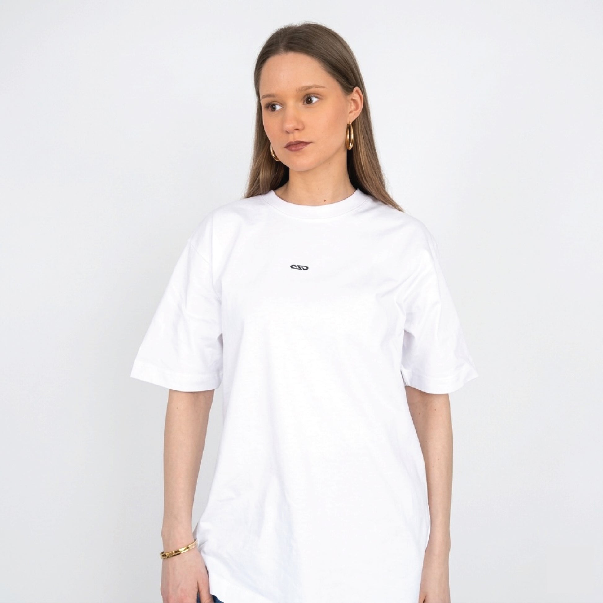 Model draagt wit Nouve Studios T-shirt met subtiele borstprint op de voorkant