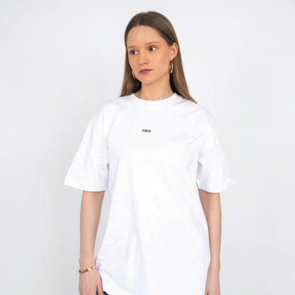 Model draagt wit Nouve Studios T-shirt met subtiele borstprint op de voorkant