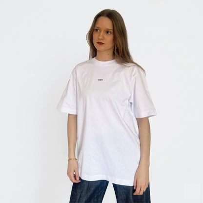 Model draagt wit Nouve Studios T-shirt met subtiele borstprint op de voorkant